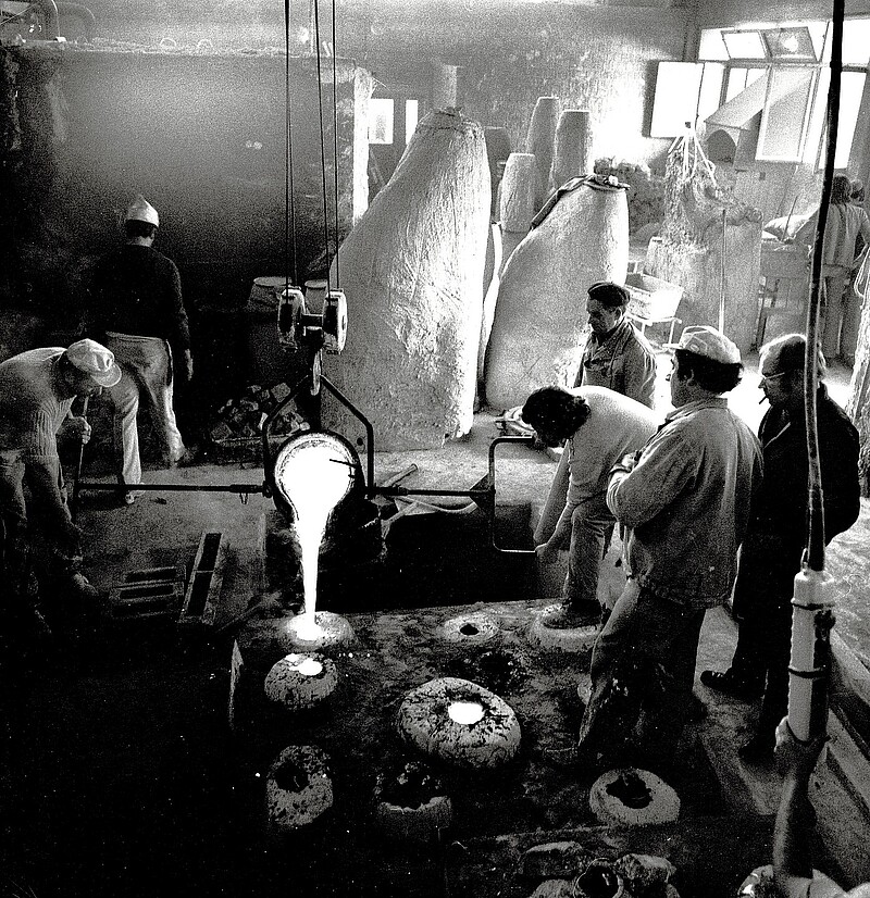 Bildhauer Max Weiss, In der Bronzegiesserei Perseo (Mendrisio) giessen Arbeiter die siedendheisse, flüssige Bronze in den beim Negativ entstandenen Hohlraum.